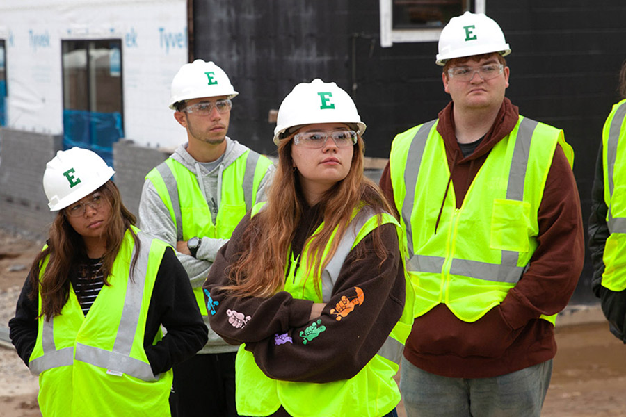Students wearing Block E construction hats and safety vests